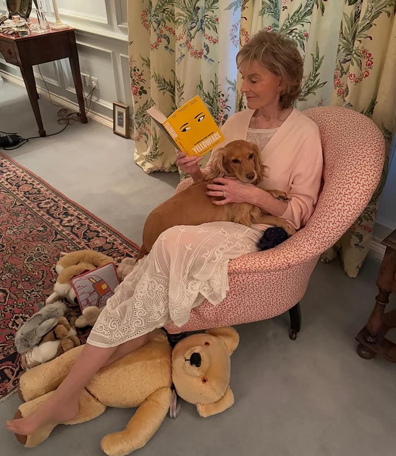 Caroline Montague reading with a dog in her lap