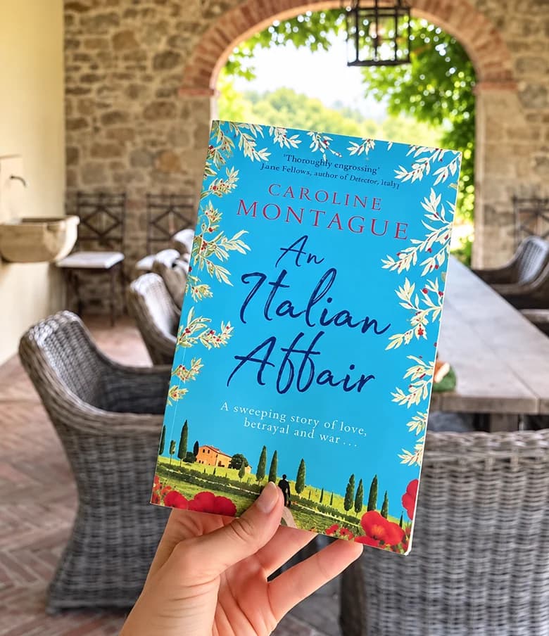 A copy of An Italian Affair by Caroline Montague held in a sunlit courtyard